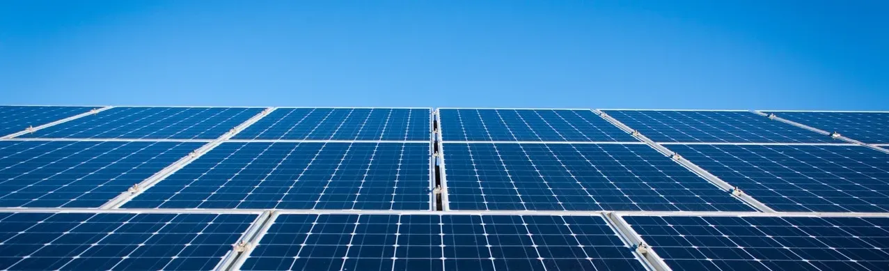 Rows of blue solar panels under a clear sky